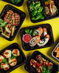 Healthy lunch at the workplace. Pick up food in black containers with cutlery