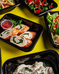 Healthy lunch at the workplace. Pick up food in black containers with cutlery
