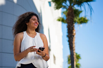 Beautiful young woman with smartphone having fun in city