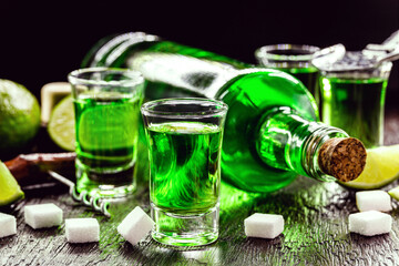 doses of absinthe with sugar cubes. Absinthe bottle, green distilled drink