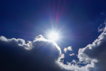 Naklejka na ściany i meble sun and rays surrounded by clouds