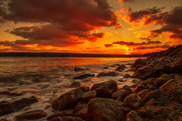 Fototapeta na wymiar Sunning long exposure sunset over the sea with a rocky beach.