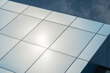 Geometric colored building facade elements with planes, lines and corners with light flare and reflections for an abstract background and texture of white, blue, gray colors. Place for text
