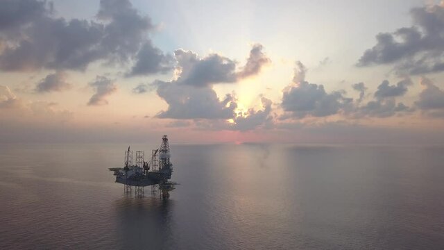 Aerial view of the jack up rig shot during sunset time. Fly around the jack up rig with a drone.
