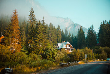 View of old houses in mountain valley in summer. Beautiful landscape with old small village in mountain valley on morning. Mountain village with picturesque summer slopes, morning light.