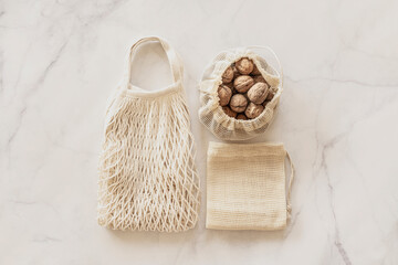Eco friendly accessories - eco bags and walnuts. Zero waste, plastic free concept, sustainable lifestyle. Top view, flat lay.