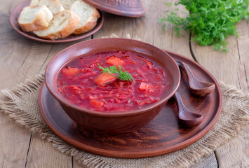 Bowl vegetable lean Borscht served with sliced white bread. Traditional Ukrainian Russian red beetroot soup. Rustic background with copy space, selective focus.