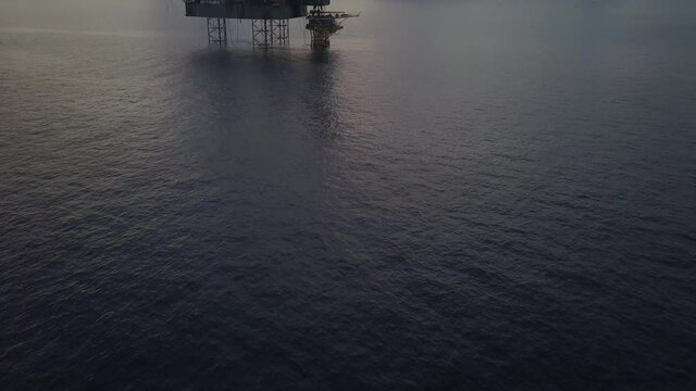 Aerial view of the jack up rig shot during sunset time. Fly around the jack up rig with a drone.
