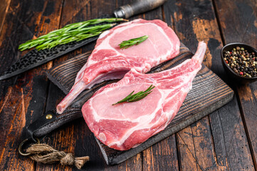 Marbled raw pork chops meat steak or tomahawk. Dark wooden background. Top view
