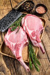 Fresh raw pork loin chops with pepper and salt. wooden background. Top view