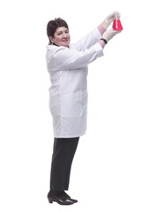 side view. a medical woman looking at a bottle of red liquid.