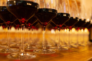 Row of elegant wine glasses with red wine on the bar