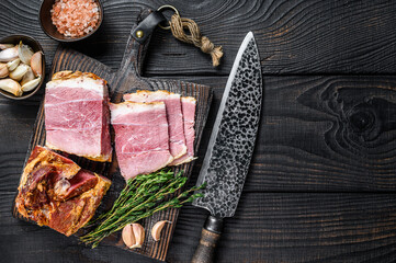Smoked Sliced Pork loin Meat on a wooden cutting board. Black wooden background. Top view. Copy space