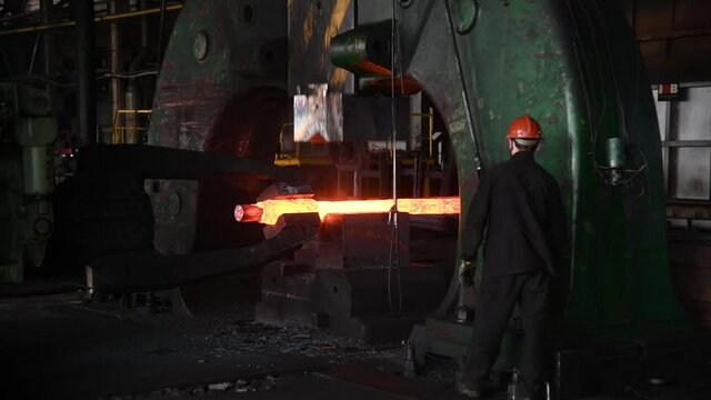 Forging a large hot metal billet with an industrial forging press