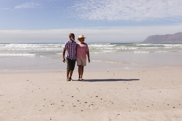 Happy senior african american couple walking together on the beach