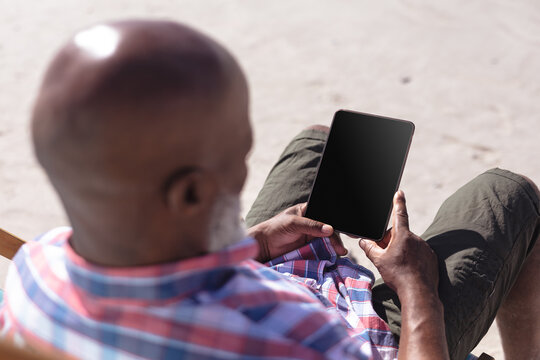 Senior African American Man Using Digital Tablet At The Beach