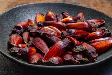 Pine cone and pine nuts (typical araucaria seed used as a condiment in Brazilian cuisine). Pine nuts, typical winter food on wooden background.