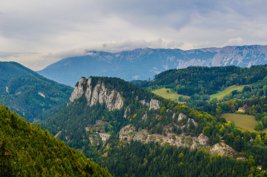 Semmering railway with surrounding mountain scenery, Krauselklause viaduct in front of Polleroswand. In the background the snowy Rax mountain range. Breitenstein am Semmering, Lower Austria, Austria