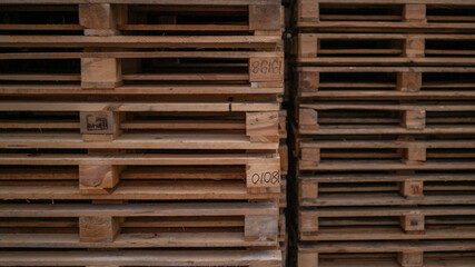 Wooden pallets for industrial and transport stacked in a large column on a warehouse