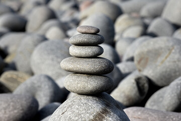 Fototapeta na wymiar Pebble stack on the beach the stones represent balance and wellbeing of the mind