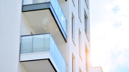 Obraz premium Detail of new luxury house and home complex. Glass surface with sunlight. Rising sun on the horizon. Part of modern residential apartment with flat building exterior. 