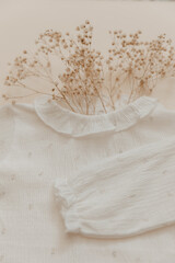 natural material concept. Soft baby bodysuit on beige background. Bohemian baby