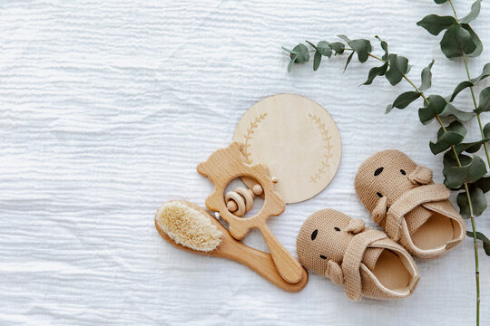 Newborn booties with empty card and wooden toys. Baby Background, top view, flat lay, copy space