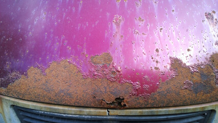 Obraz na płótnie Canvas Sheet metal corrosion of old red purple car. Rusty messy surface. Damaged grunge dirty texture from road salt. Rust background. Protecting the automobile concept. Copy space. Resistance test. Paint.