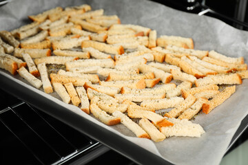 Taking baking pan with hard chucks out of oven, closeup