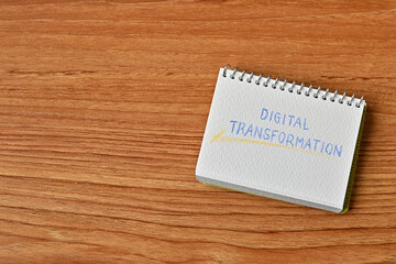 A small sketchbook labeled Digital Transformation sits on the table.