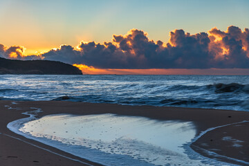 Sunrise at the seaside with low cloud bank