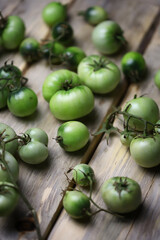 Green tomatoes on a wooden surface. Harvest the tomato. Green tomatoes for fermentation.