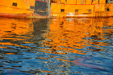 Fototapeta na wymiar Fishing boat reflections in the water