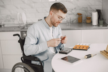 Young disabled man repairing motherboard at kitchen