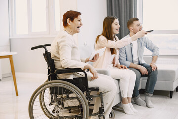 Woman in wheelchair watch tv with caregivers
