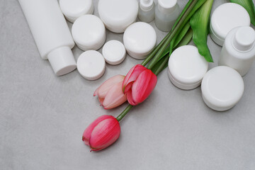 Mock-up..Empty bottles, jars for gel, lotion, cream..White plastic containers for skincare products without labels..Unbranded beauty product package..Decorated with tulip..Cosmetic or pharmacy concept - 429114192