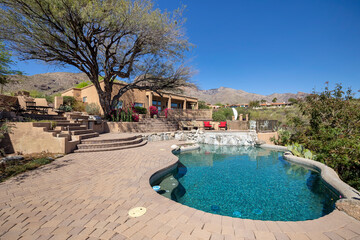 Swimming pool with hot tub and terraced patio at a luxury home in a desert environment. - Powered by Adobe