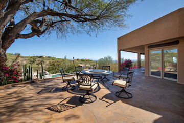 Swimming pool with hot tub and terraced patio at a luxury home in a desert environment.