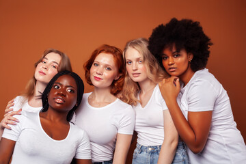 Obraz premium young pretty caucasian, afro, scandinavian woman posing cheerful together on brown background, lifestyle diverse nationality people concept