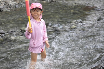 水鉄砲で川遊びをする幼児(5歳児)