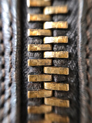 Closeup macro shot of a brass zipper on leather boots © Julia