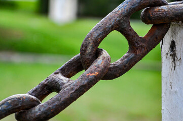 Strong rusted old chain with grass behind
