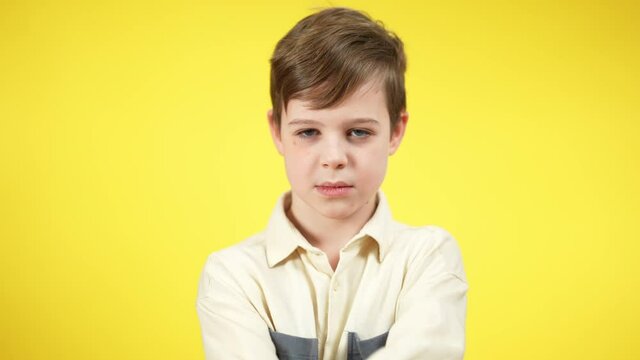 Unhappy Caucasian Boy Crossing Hands Shaking Head No Looking At Camera. Portrait Of Dissatisfied Sad Kid Posing At Yellow Background. Rejection And Disapproval Concept