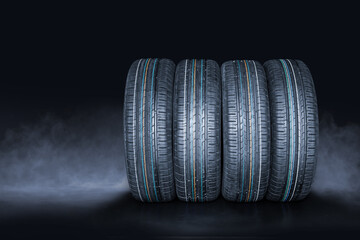 Summer car tires on black smoke background, tire changing