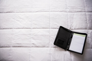 notebook folio on white bedspread