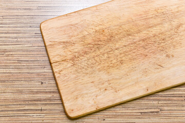 Old chopping board on wooden background top view