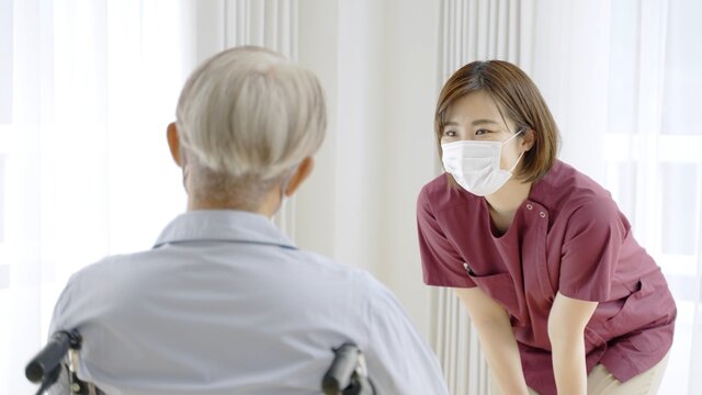 患者に説明をするマスクを着用した看護師