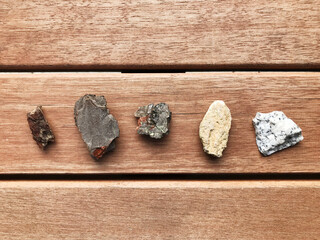 Various material of pebbles on wooden board