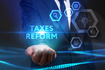 Business, Technology, Internet and network concept. Young businessman working on a virtual screen of the future and sees the inscription: Taxes reform