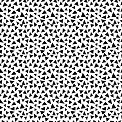 Seamless pattern. Black triangles in chaotic order on a white background.